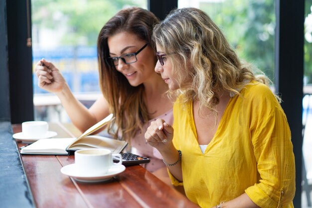 Mujeres enfocadas que beben el café y que trabajan en café | Foto ...