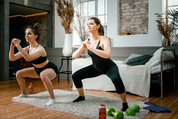 Las mujeres jóvenes practican deportes en casa hacen ejercicio en