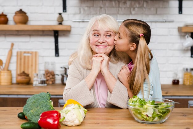 Nieta Besando A Su Abuela En La Mejilla Foto Gratis