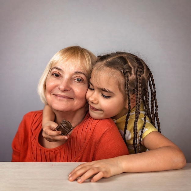 Ni A Abrazando A Su Abuela Con Amor Y Comiendo Barras De Chocolate Con