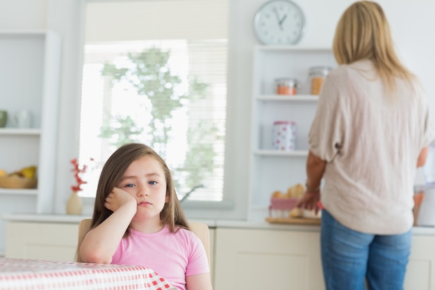 Niña aburrida en la cocina | Foto Premium