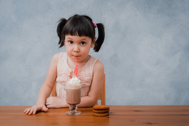 Nina Pequena Bebe Chocolate Caliente O Chocolate Con Galletas A Traves De Un Tubo De Coctel Foto Premium