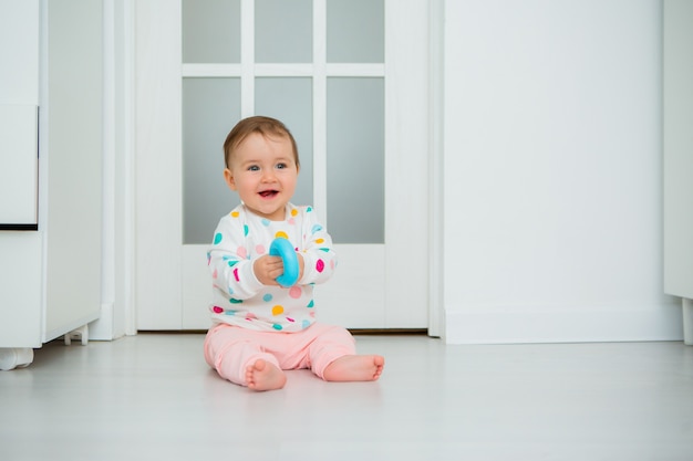 La Nina Pequena Juega Juegos Educativos En Casa El Bebe Se Sienta En El Piso De La Casa Foto Premium