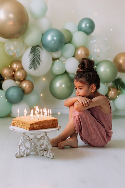 Niña pide deseo y sopla las velas de la tarta de cumpleaños niña