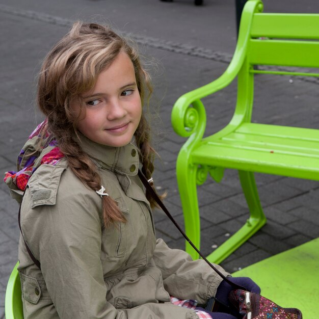 Niña Sentada En El Banco Del Parque En La Acera Foto Premium 