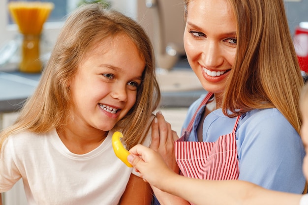 Ni A Sonriente Ayudando A Su Madre En La Cocina Foto Premium