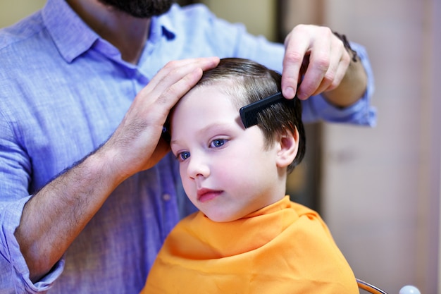 Niño Cortarse El Pelo En La Peluquería Foto Premium