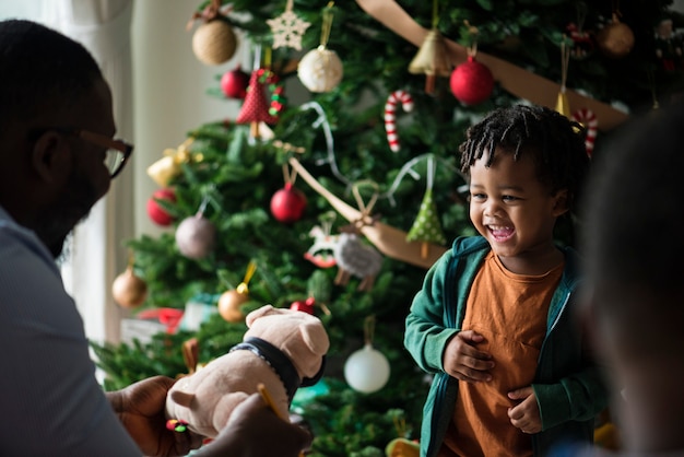 Niño feliz recibiendo un regalo de navidad | Foto Premium