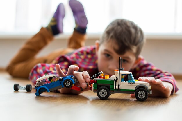 Niño Juega Con Coches De Juguete Niño Jugando En El Suelo Diversión