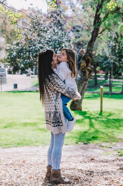 Nino Lindo Bebe Nina Beso En La Mejilla Y Abrazo Abrazo Con Mujer Bonita Feliz En Parque Verde Foto Premium