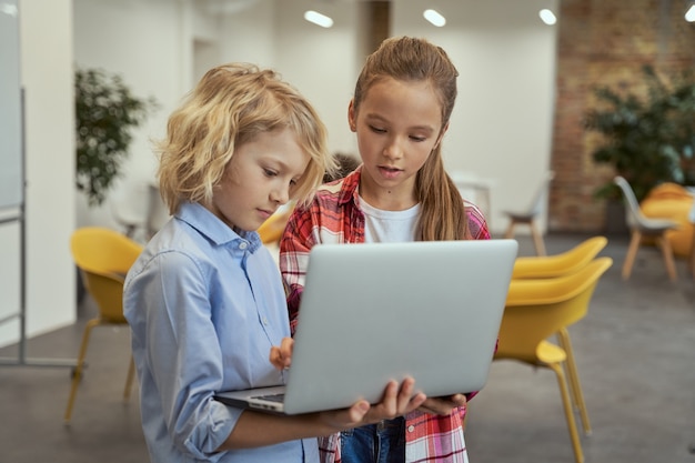 Niño Y Niña Aprendiendo A Programar Mirando La Pantalla Del Portátil Mientras Está De Pie En Un 