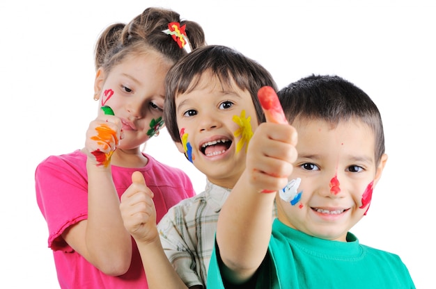 Niños desordenados con pintura en sus manos y caras con los ...