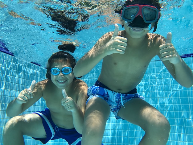 Niños disfrutando en la piscina bajo el agua Foto Premium