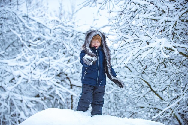 Los niños de invierno los niños de ocio corren en el campo nevado los