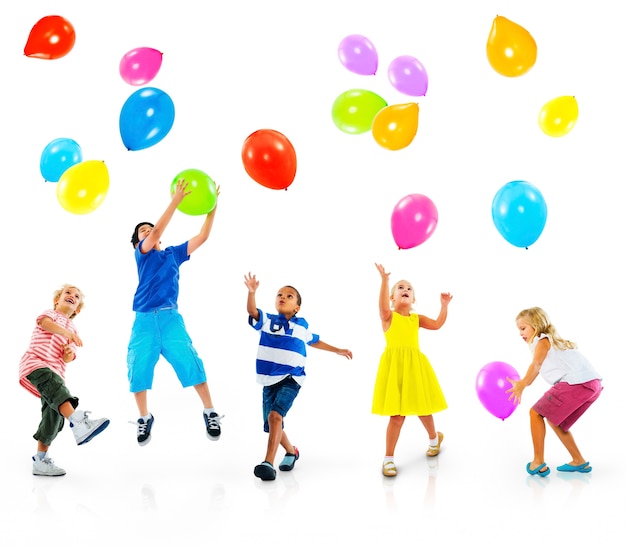 Niños jugando con globos de colores | Foto Premium