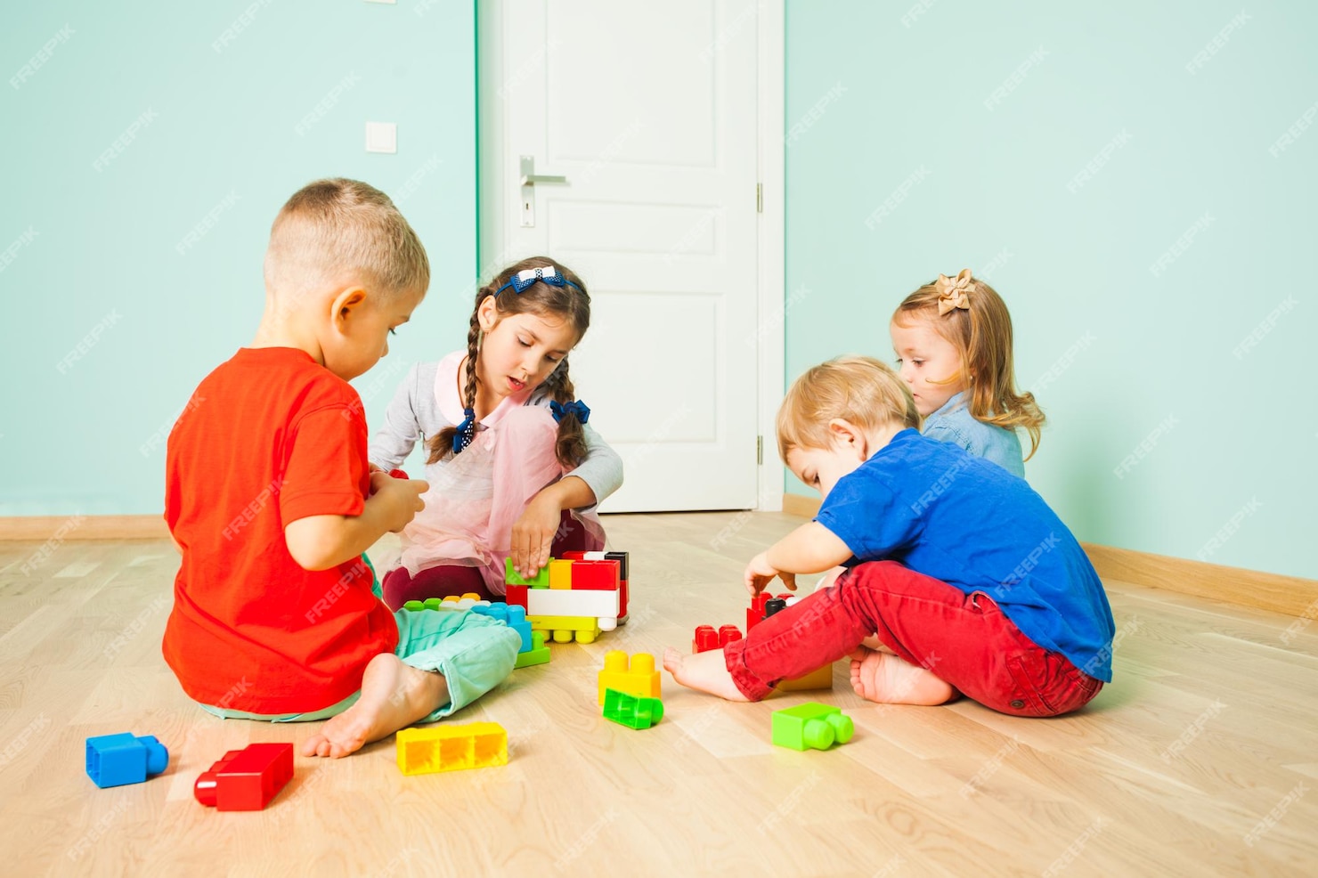 Niños y niñas jugando con bloques de juguete de construcción ...