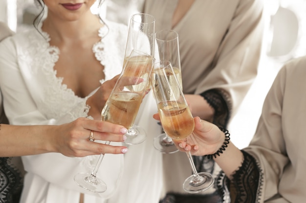 La novia y el novio sostienen copas de cristal llenas de champán Foto Premium 