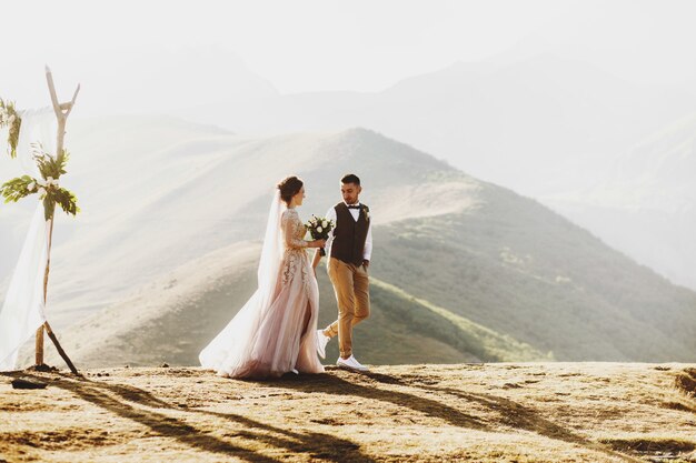 La Novia Y El Novio Se Ven Hermosos Durante La Ceremonia De La Boda En La Cima De La Montana En Algun Lugar De Georgia Foto Premium