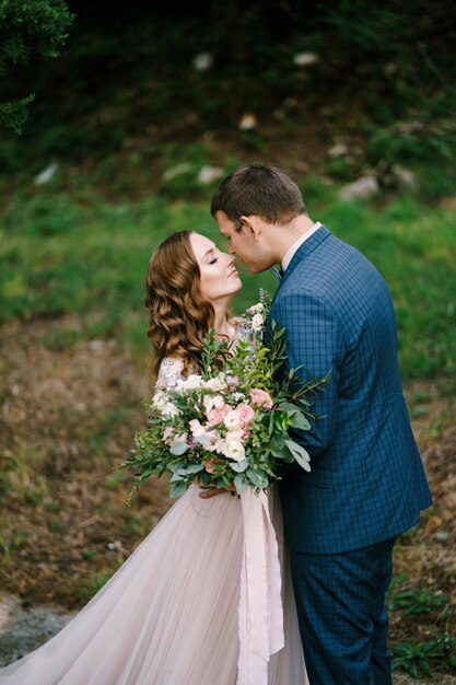 La Novia Con Un Ramo Casi Besa Al Novio En El Jardín Foto Premium 