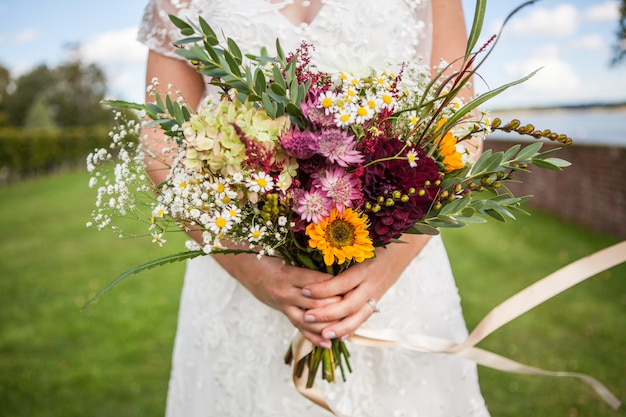 La novia sostiene un ramo de flores frescas de primavera y ...