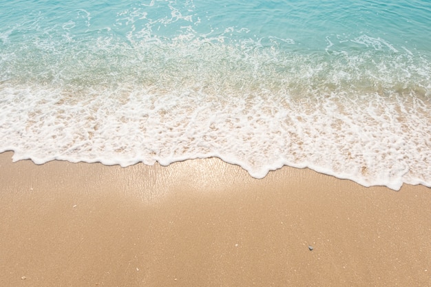 Ola de océano azul en la playa de arena textura de fondo Foto Premium