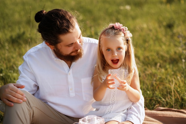 Padre E Hija En Un Picnic De Verano Nina Bebe Jugo De Un Vaso Y Feliz Foto Premium