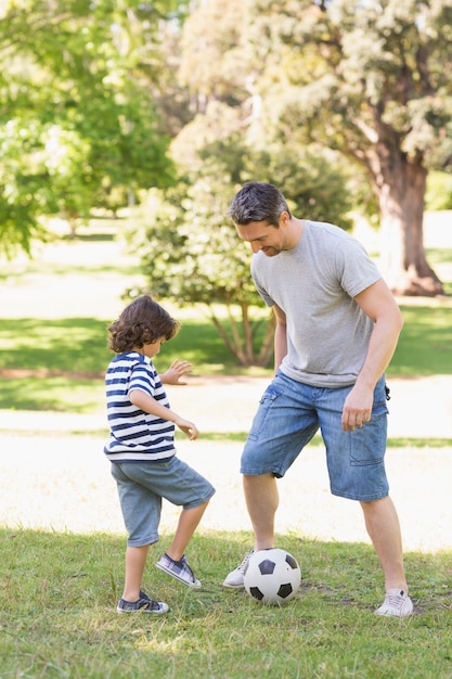 Padre E Hijo Jugando Al Futbol En El Parque Foto Premium