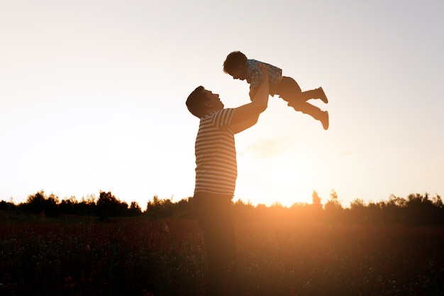 Padre e hijo jugando en el parque a la hora del atardecer. familia feliz  divirtiéndose al aire libre | Foto Gratis