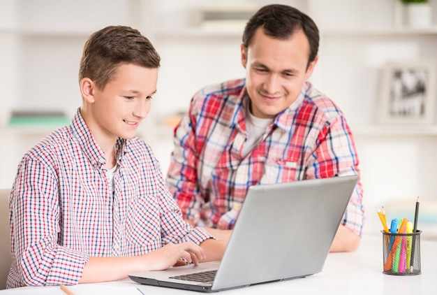 Padre E Hijo Usando La Computadora Portátil Juntos En Casa Foto Premium 