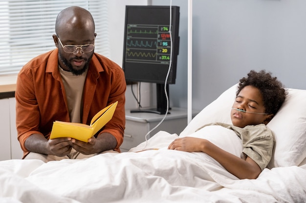 Padre Leyendo Un Libro A Su Hijo En El Hospital Foto Premium