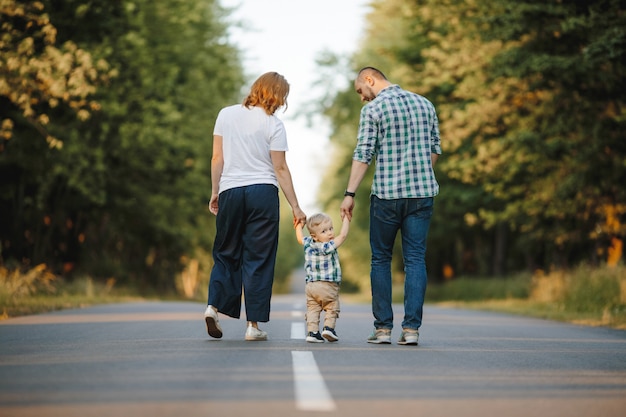 Los Padres Que Sostienen A Su Pequeño Hijo Están Caminando Por Un Camino Foto Gratis 4093