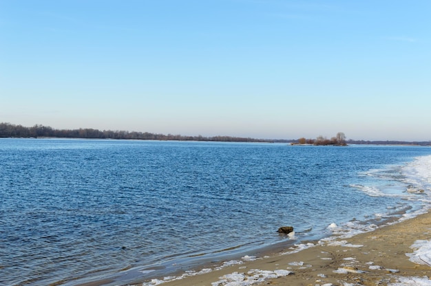 Paisaje invernal una vista del ancho río en una orilla vacía trozos de