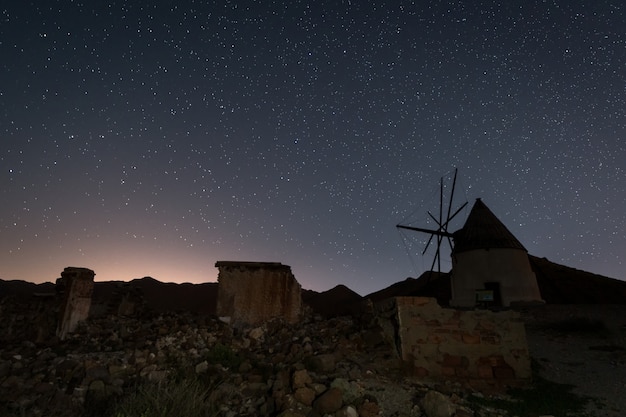 Paisaje nocturno con molino de viento blanco tradicional ...