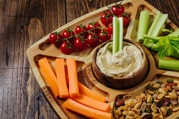 Palitos De Hummus Y Verduras De Zanahoria Y Apio En Una Placa De Madera