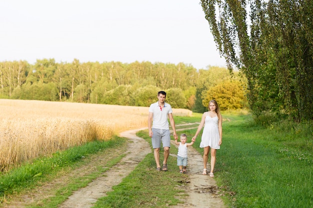 Papa Mama Y Bebe Estan Caminando En La Carretera Cerca Del Campo Foto Premium