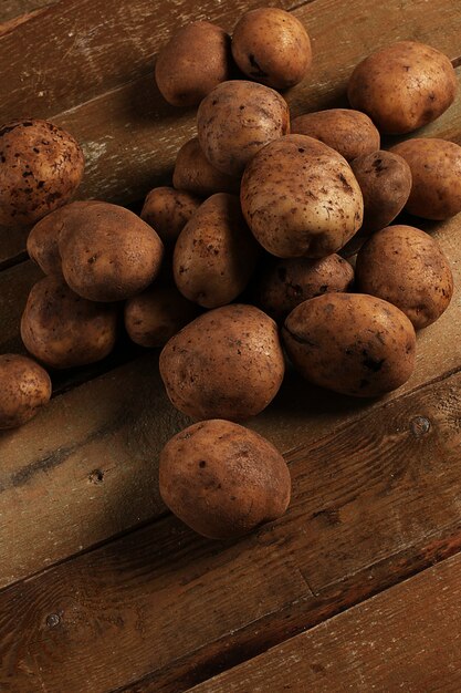 Papas rústicas sin pelar en un escritorio Foto gratis