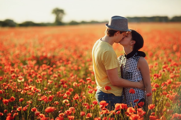 Pareja Besándose En Un Campo De Flores Rojas Foto Premium 2592