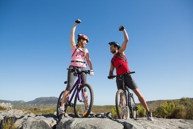 Pareja De Ciclistas Aptos Animando En La Cumbre Foto Premium 