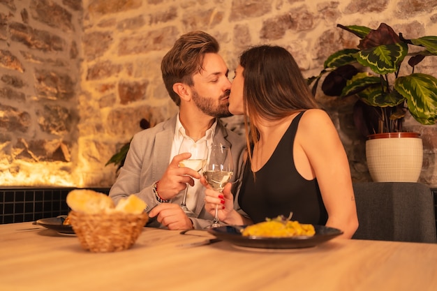 Pareja De Enamorados Besándose En Un Restaurante Divirtiéndose Cenando Junto Con La Comida