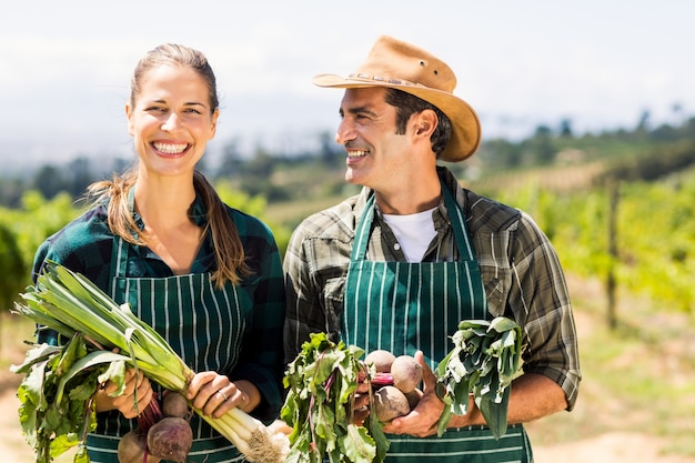 Pareja feliz agricultor con verduras de hoja Foto Premium 