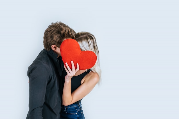 Pareja feliz amando juntos sosteniendo un corazón rojo Foto gratis
