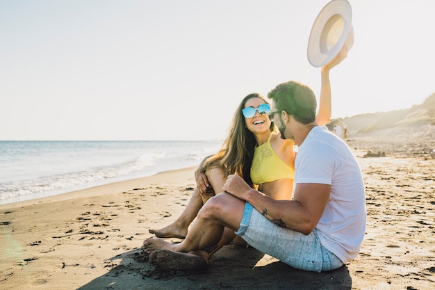 Pareja Feliz Sentada En La Playa Foto Gratis