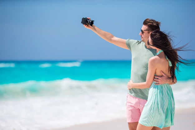 Pareja Feliz Tomando Una Foto En Una Playa En Vacaciones Foto Premium