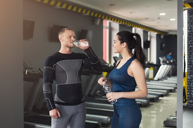 Pareja De Fitness Descansar Beber Agua En El Gimnasio Hombre Y Mujer Sonrientes Con Botellas 4054