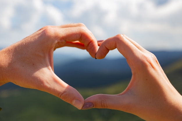 La Pareja Hace Un Corazón Con Las Manos En El Fondo Del Cielo Foto