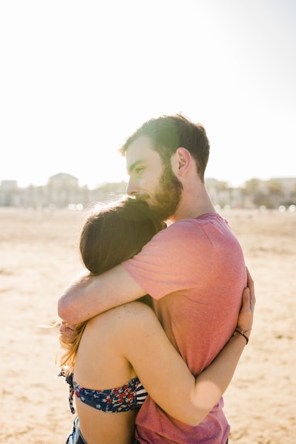 Pareja Joven Abrazándose En La Playa De Arena En Un Día Soleado Foto Gratis 