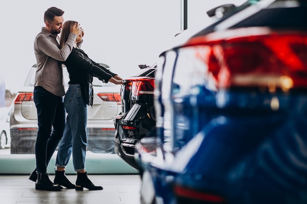 Pareja Joven Eligiendo Un Automóvil En Una Sala De Exhibición De Autos Foto Gratis 