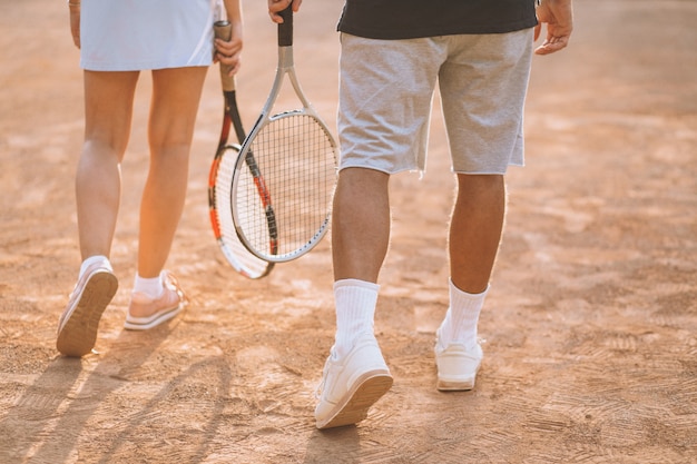 Pareja joven jugando al tenis en la cancha, pies de cerca Foto gratis