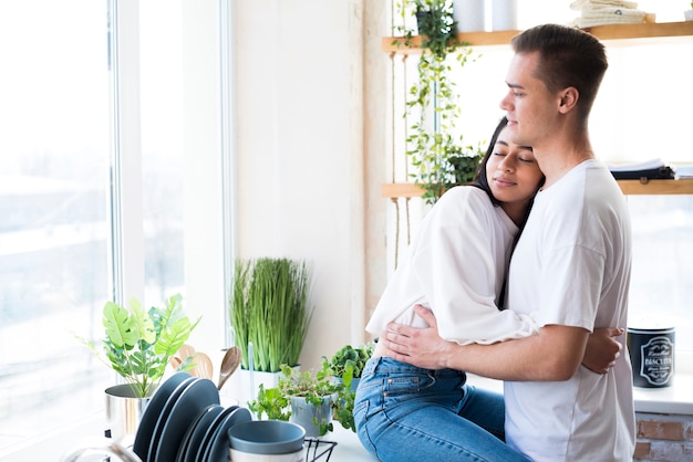 Pareja Joven Multiétnica En El Amor Que Abraza En Cocina Foto Gratis 