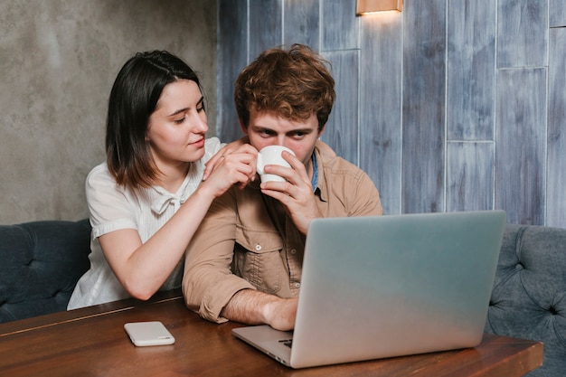 Pareja joven trabajando en la computadora portátil Foto gratis